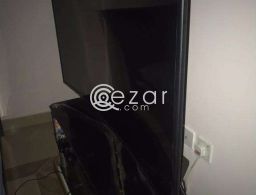curved 55 inch UHD TV with quality glass cabinet in Qatar